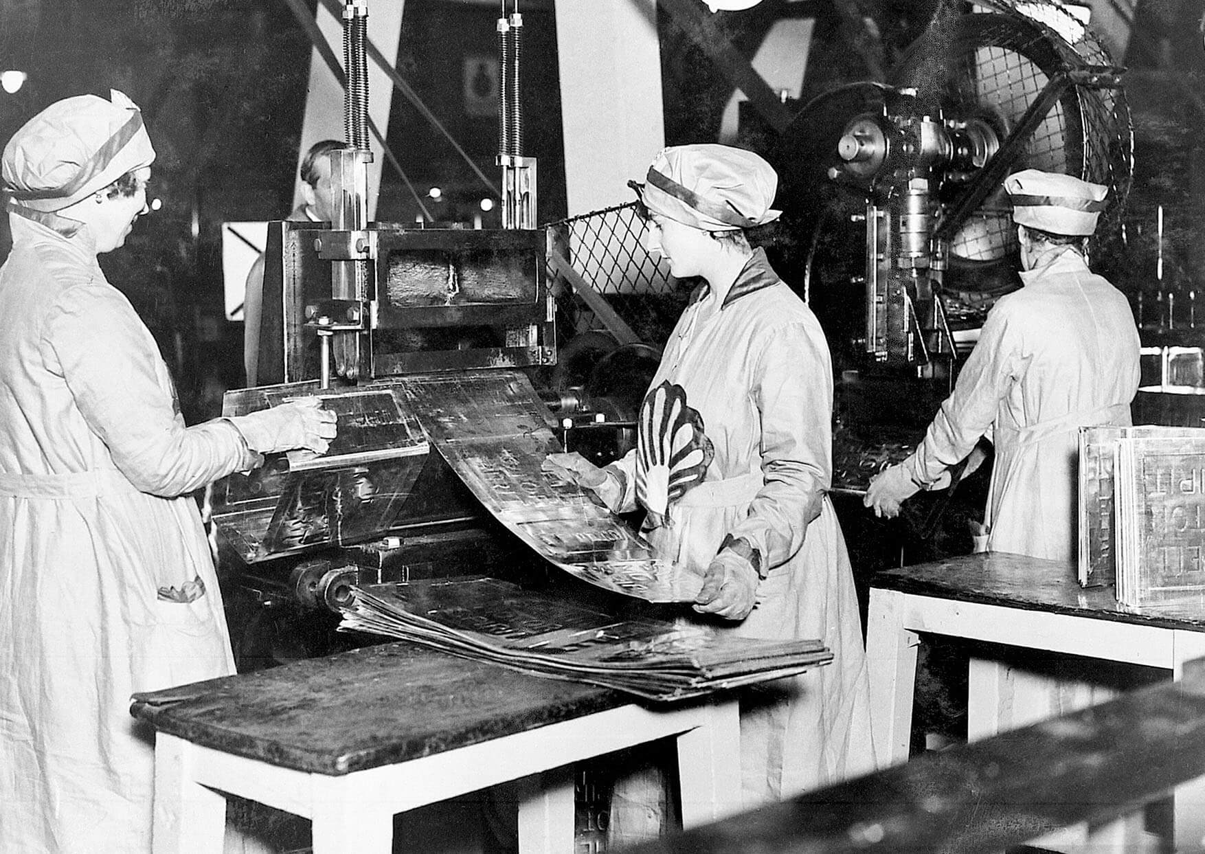 Black and white photograph of female workers in a Shell factory bending metal sheeting to produce fuel cans